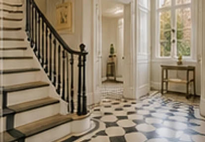 Elegant staircase and checkerboard-tiled hallway in a Chelsea townhouse.