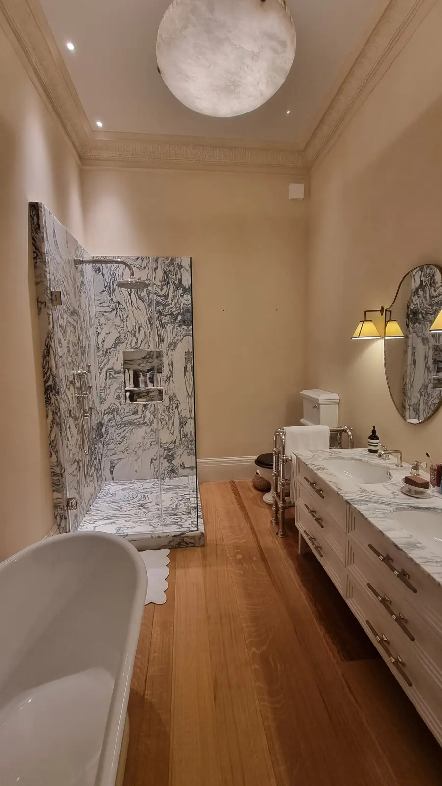 Finished bathroom with marble shower enclosure and freestanding bath, following PEP plumbing and heating installation.