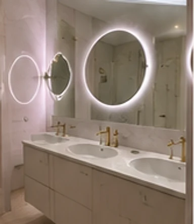 Styled double-vanity bathroom design with illuminated round mirrors, Kensington W8.